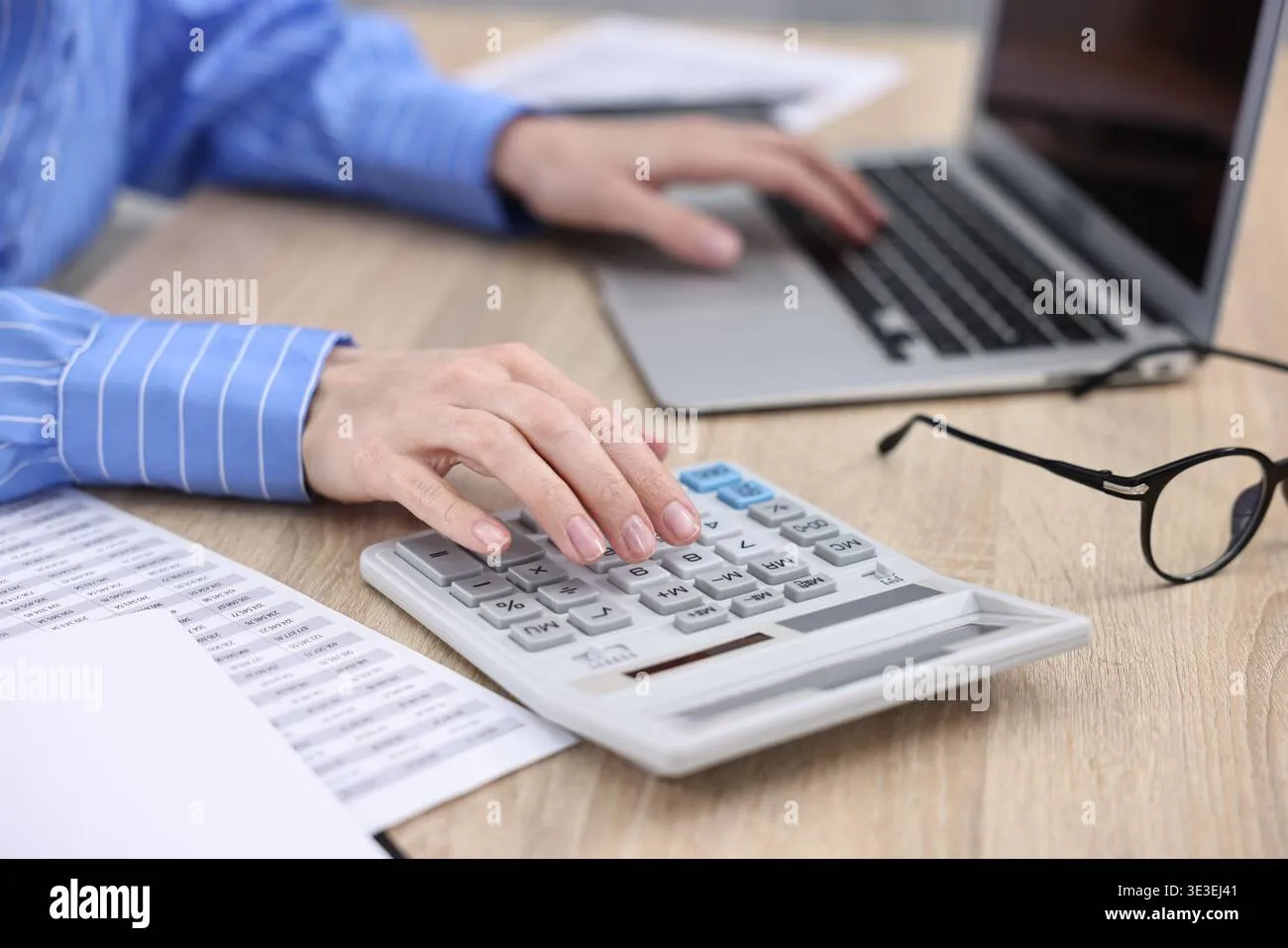 budget-planning-woman-using-calculator-and-working-on-laptop-at-wooden-table-indoors-closeup-3e3ej41 Xây dựng kế hoạch tài chính cụ thể giúp gia đình giảm bớt áp lực tiền bạc