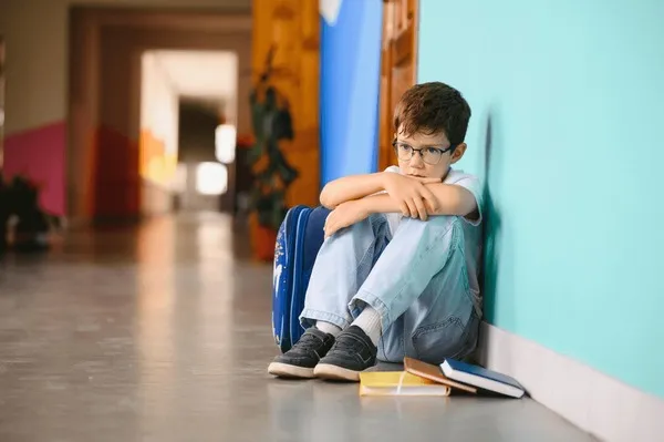 young-boy-sitting-alone-sad-600nw-2501772911 Bạo lực học đường để lại những nỗi đau tinh thần sâu sắc cho học sinh